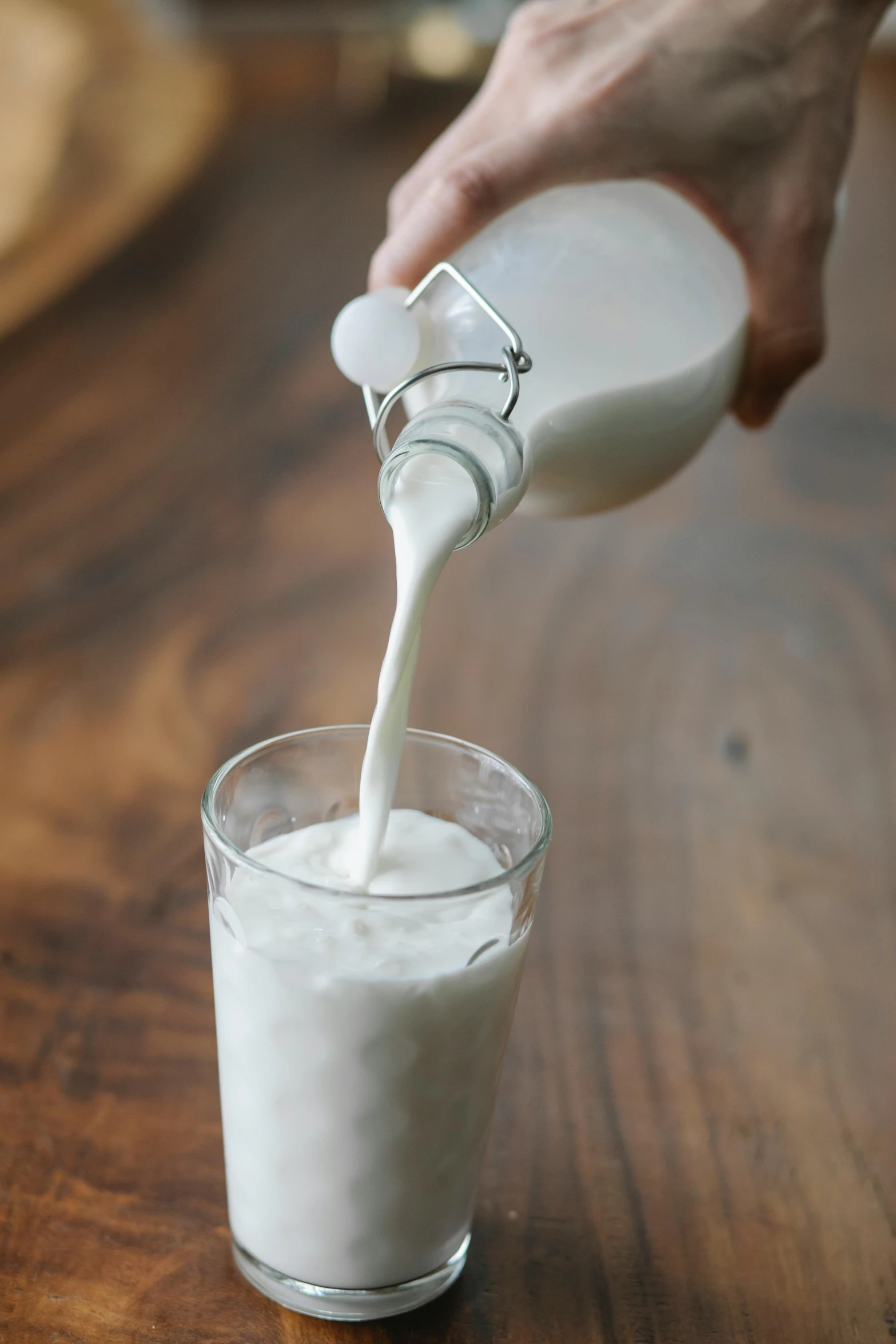 a person pouring milk into a glass on a table, bao pham, medium, “organic, at home