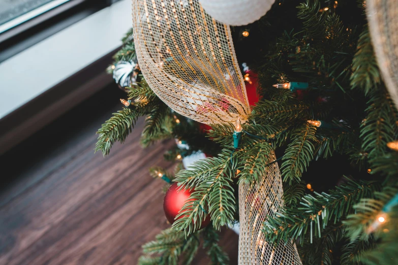 a close up of a christmas tree with ornaments, pexels, arabesque, ribbon, thumbnail, high angle close up shot, over-the-shoulder shot