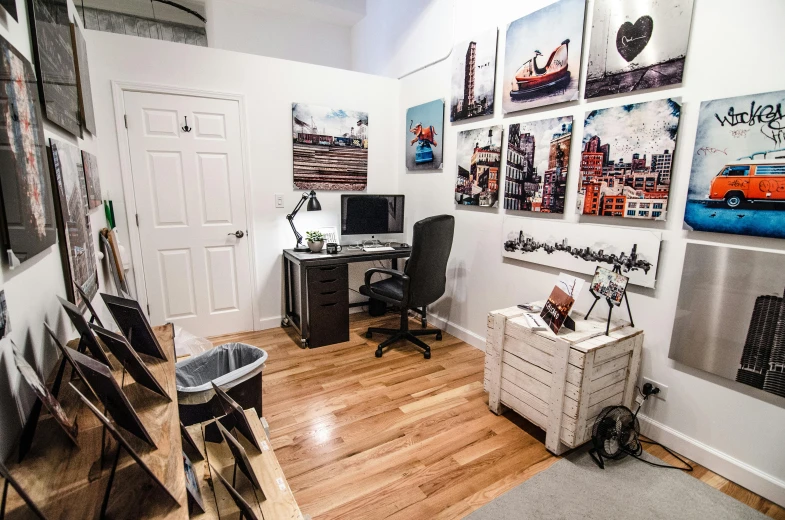 a room with a desk a chair and pictures on the wall, by Josh Bayer, temporary art, 4k studio photo, gopro photo, a quaint, bright ”