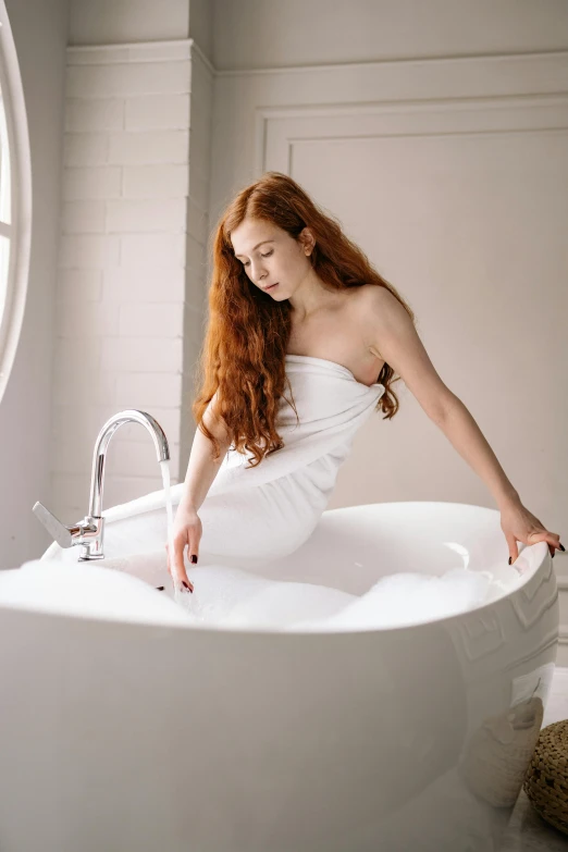 a woman sitting in a bathtub next to a window, inspired by Pierre Auguste Cot, trending on pexels, long ginger hair, soft flawless pale skin, standing elegantly, on a white table
