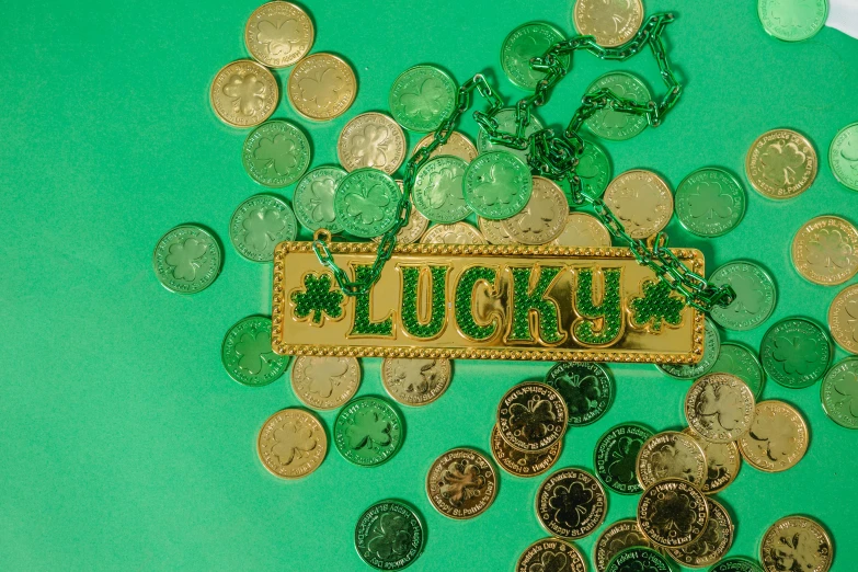 a bunch of coins sitting on top of a table, an album cover, pexels contest winner, hurufiyya, green tones and golden charms, lucky star, 4k -4, gold embroidery