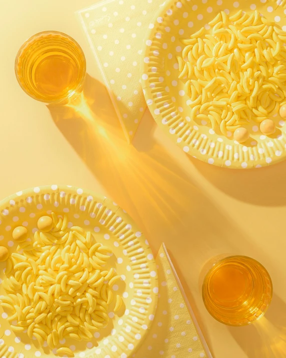 two bowls of noodles sitting on top of a table, inspired by Leo Leuppi, pexels contest winner, photorealism, yellow background beam, cooking oil, light scatter, soft diffused light