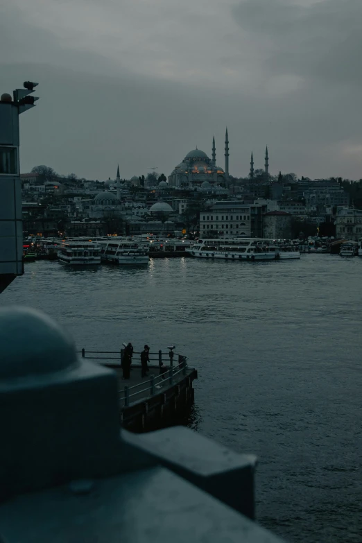 a large body of water with a city in the background, a colorized photo, pexels contest winner, hurufiyya, black domes and spires, overcast dawn, fallout style istanbul, slide show