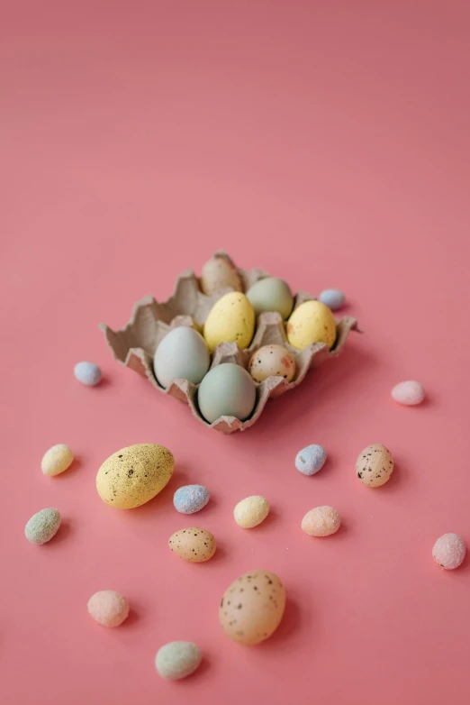 a basket filled with eggs on top of a pink surface, by Alison Geissler, trending on unsplash, made of candy, seeds, set photo, grey