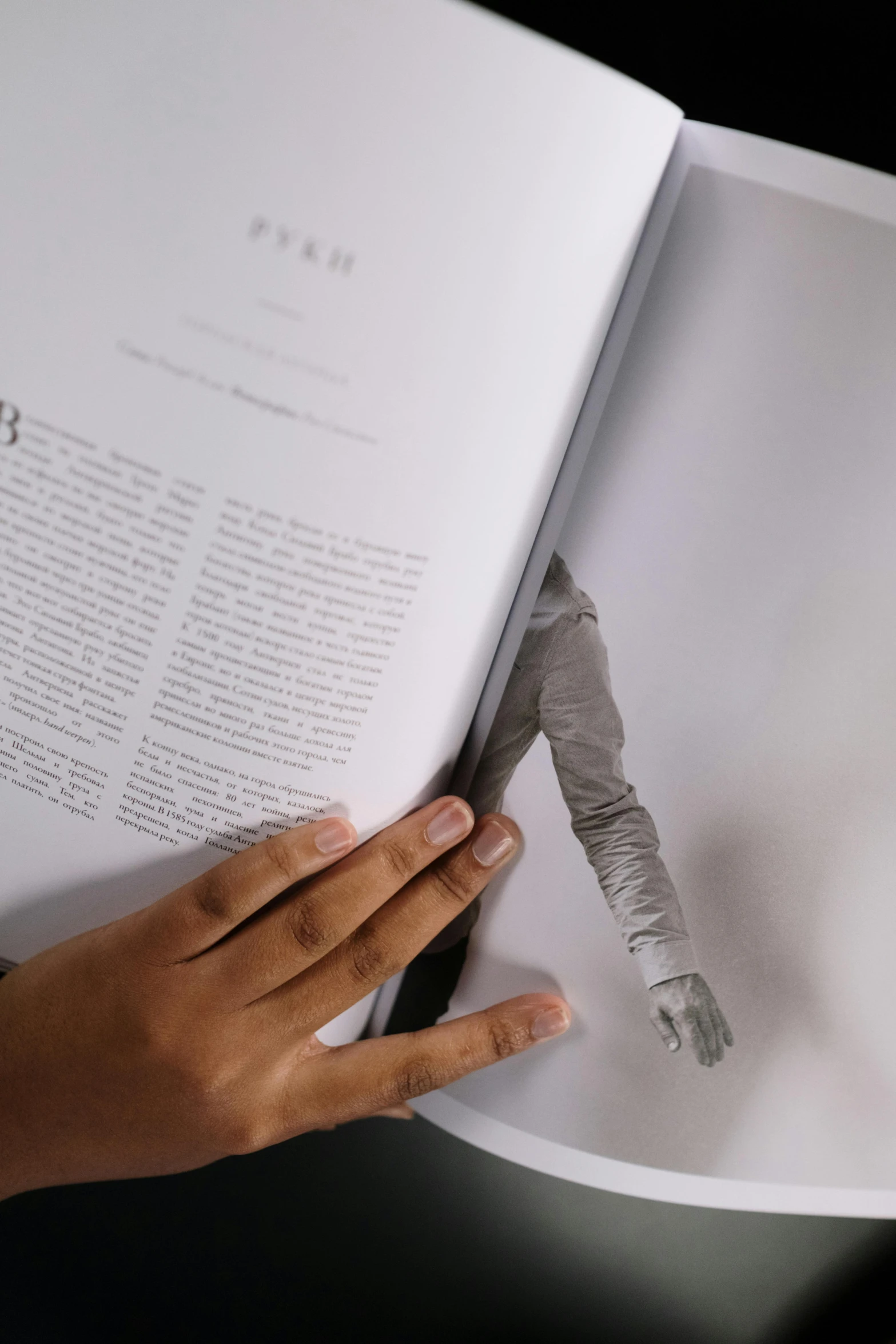 a close up of a person holding an open book, inspired by Anna Füssli, interactive art, made of cement, plated arm, on high-quality paper, humans exploring