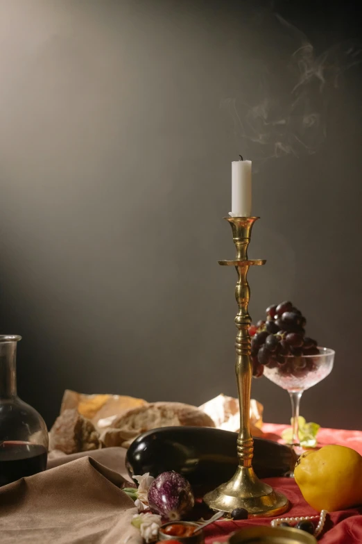 a candle sitting on top of a table next to a glass of wine, a still life, inspired by Caravaggio, incense smoke fills the air, scepter, creterion collection, made of polished broze