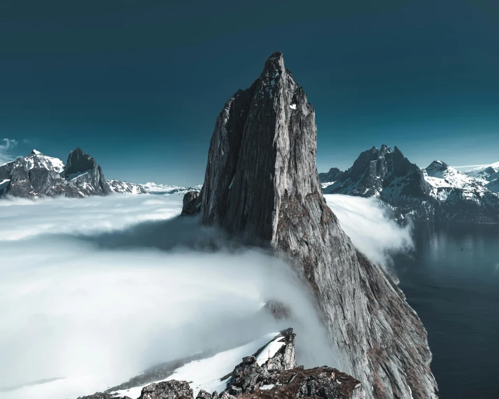 a person standing on top of a snow covered mountain, a matte painting, pexels contest winner, surrealism, spire, “ aerial view of a mountain, grey, balaskas