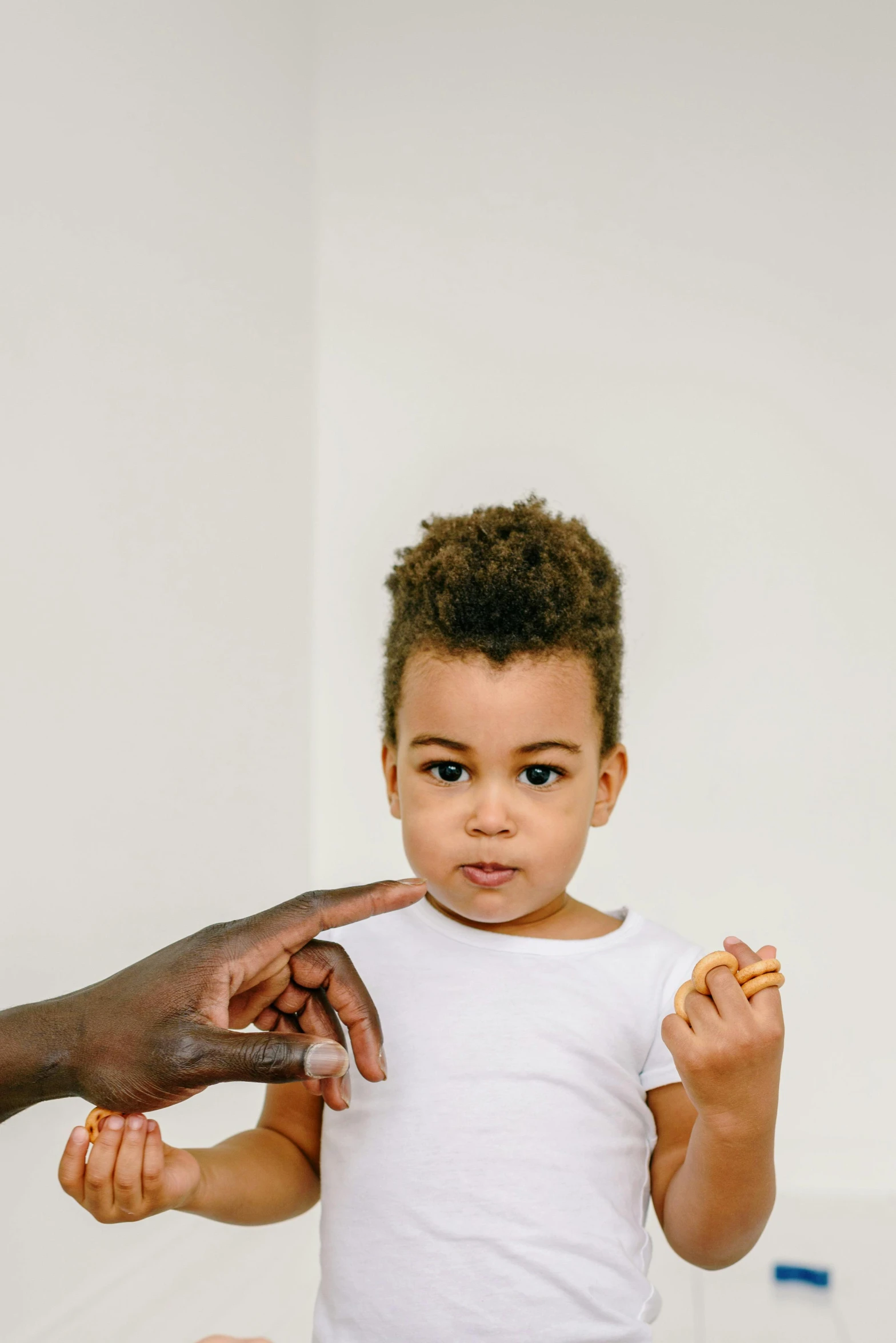 a close up of a person holding a child, pexels contest winner, with pointing finger, with brown skin, modeling, toddler