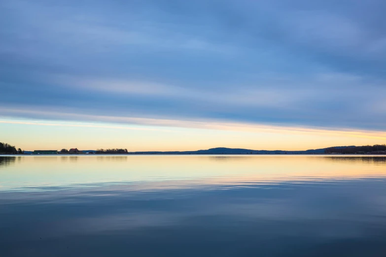 a large body of water next to a forest, by Doug Ohlson, minimalism, blue sky at sunset, fine art print, espoo, islands on horizon