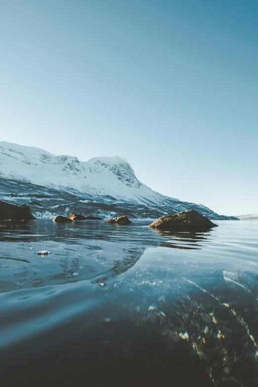 a body of water with a mountain in the background, by Tobias Stimmer, pexels contest winner, arctic fish, clear skies, outside winter landscape, concept photo