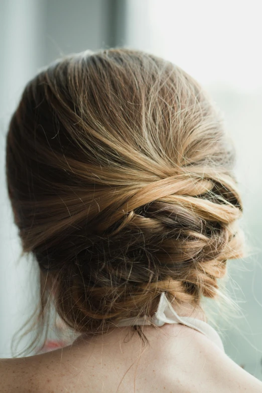 a woman with her back to the camera looking out a window, playful updo, hair texture, from side, wedding