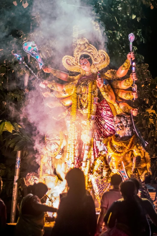 a group of people standing around a fire with a statue in the background, pexels contest winner, happening, wearing an ornate outfit, tiger of fire flying, calcutta, slide show