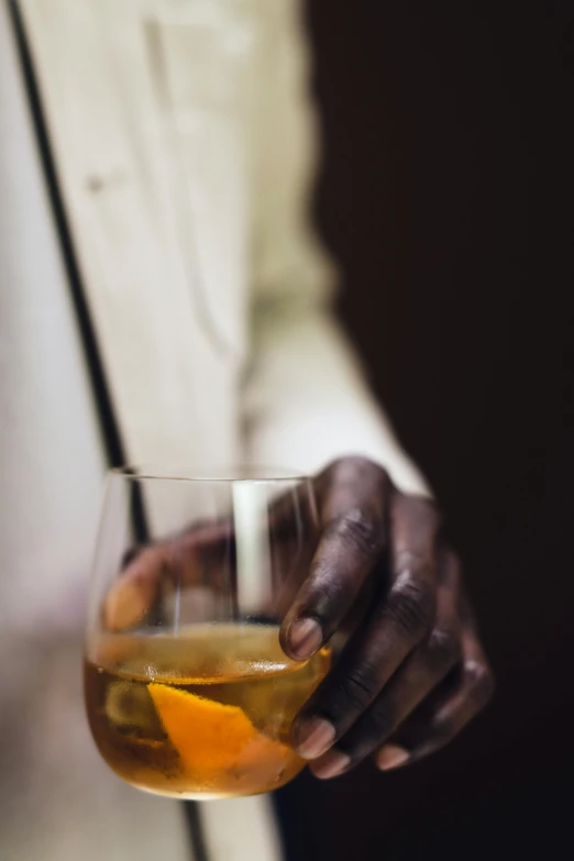 a close up of a person holding a glass of alcohol, inspired by William Grant Stevenson, dark skinned, ignant, cuban setting, brown