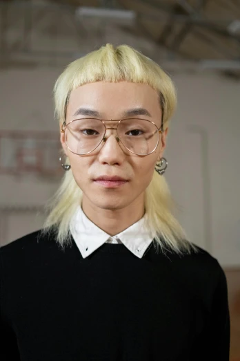 a woman with blonde hair wearing glasses and a black shirt, inspired by Fei Danxu, white ponytail hair, nicodemus yang-mattisson, gold hair, with symmetrical facial features