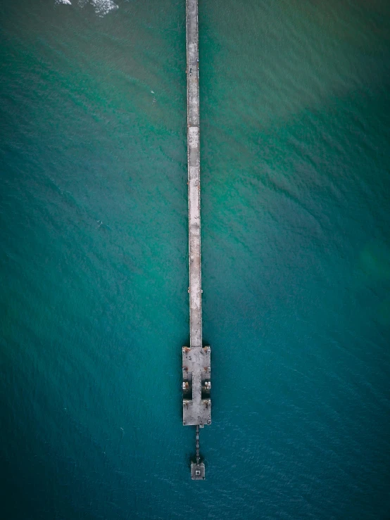 an aerial view of a pier in the middle of the ocean, by Niko Henrichon, portrait photo, high quality image, multiple stories, a green