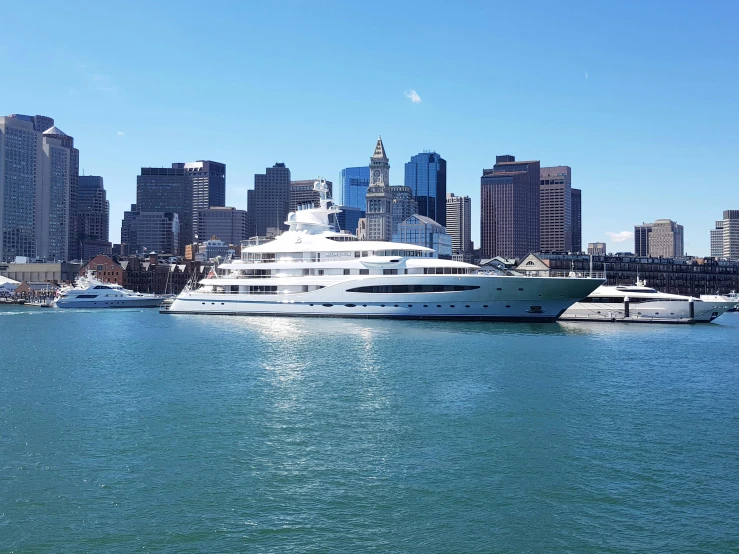 a large white boat floating on top of a body of water, boston, on a super yacht, surrounding the city, slide show