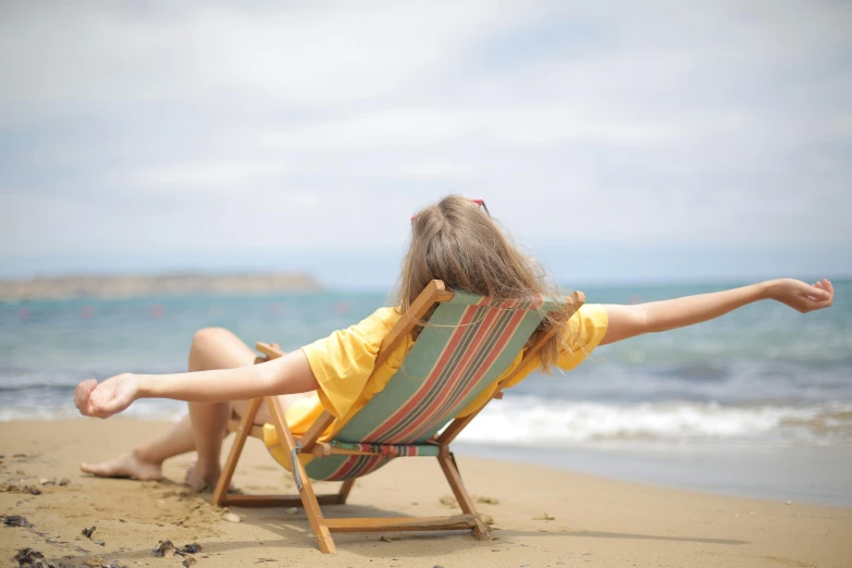 a little girl sitting in a lawn chair on the beach, pexels contest winner, renaissance, arms extended, woman on the beach, on a yellow canva, hd wallpaper