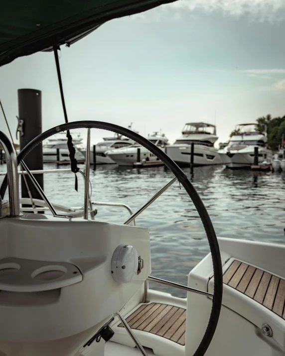 a close up of a steering wheel on a boat, pexels contest winner, happening, sailboats in the water, small dock, thumbnail, 8k octan photo