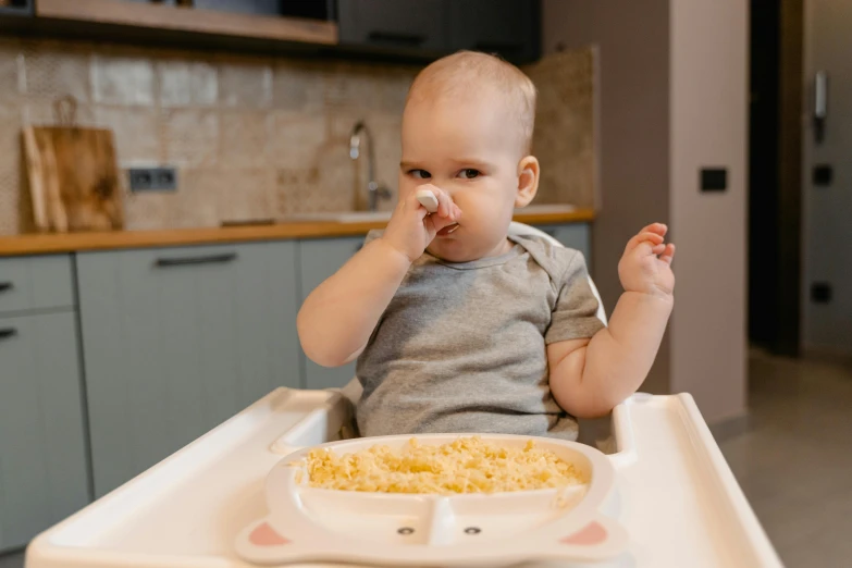 a baby sitting in a high chair eating food, pexels contest winner, flowing mucus, extremely handsome, bowater charlie and brom gerald, 1 2 9 7