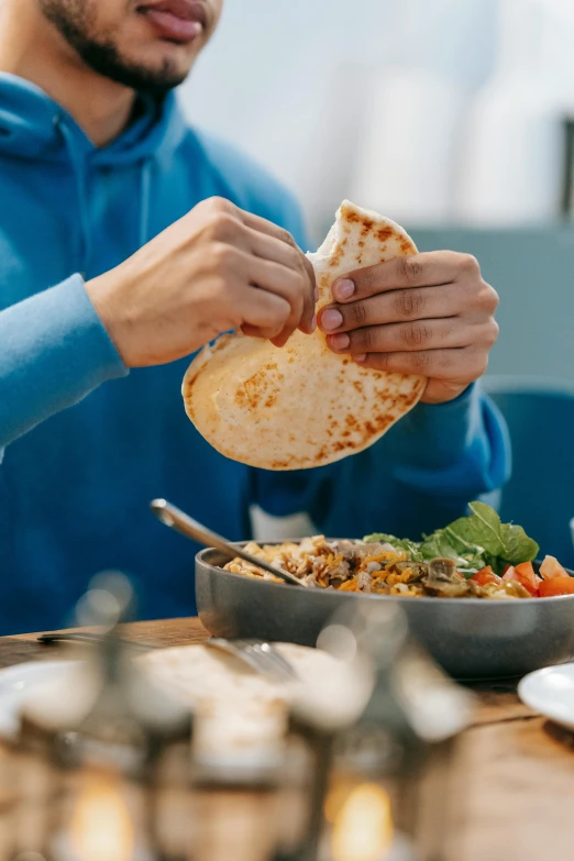 a man sitting at a table with a plate of food, pexels contest winner, flat pancake head, bowl filled with food, middle eastern details, hands on counter