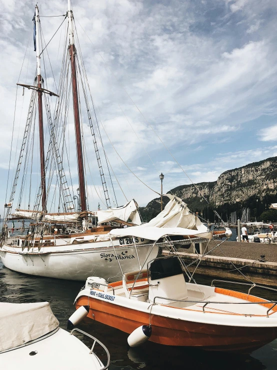 a couple of boats that are sitting in the water, pexels contest winner, renaissance, docked at harbor, capri coast, he's on an old sailing boat, white and orange