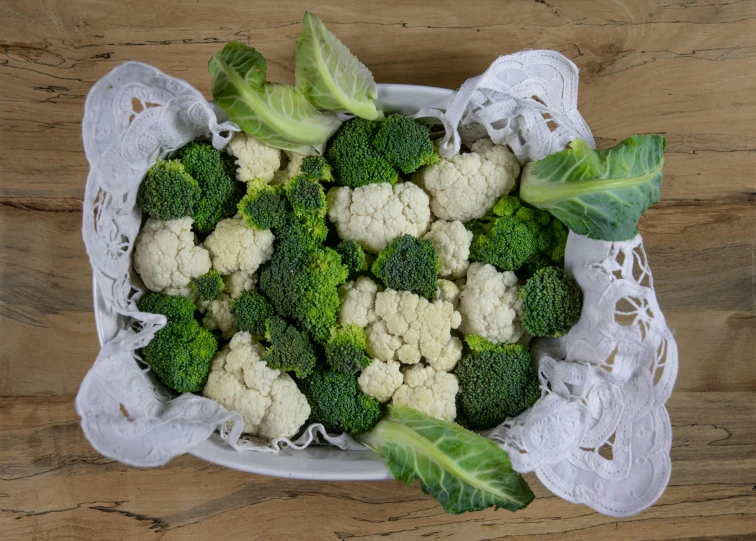 a bowl of broccoli and cauliflower on a table, unsplash, renaissance, in a wooden box. top down photo, various posed, with a white, fine foliage lace
