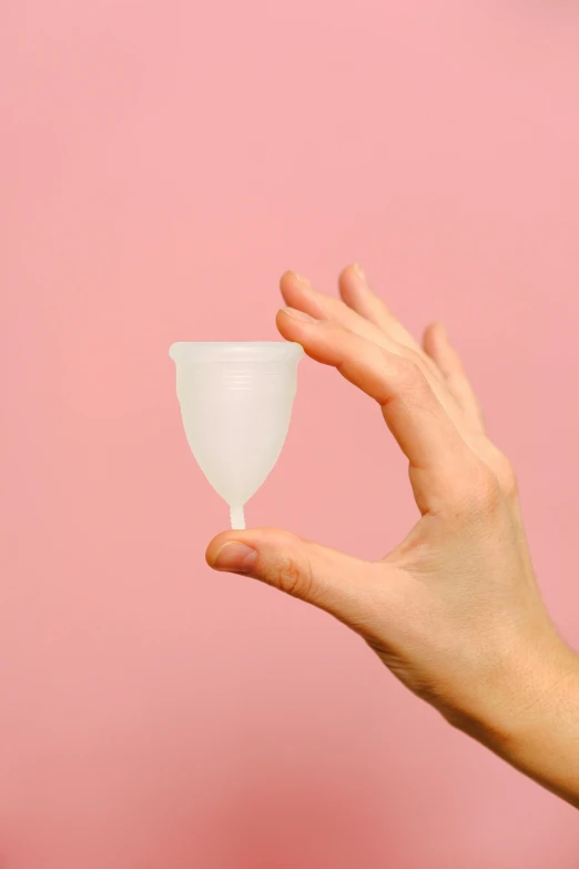 a person holding a glass in their hand, by Rachel Reckitt, plasticien, contracept, close-up product photo, pink, petite