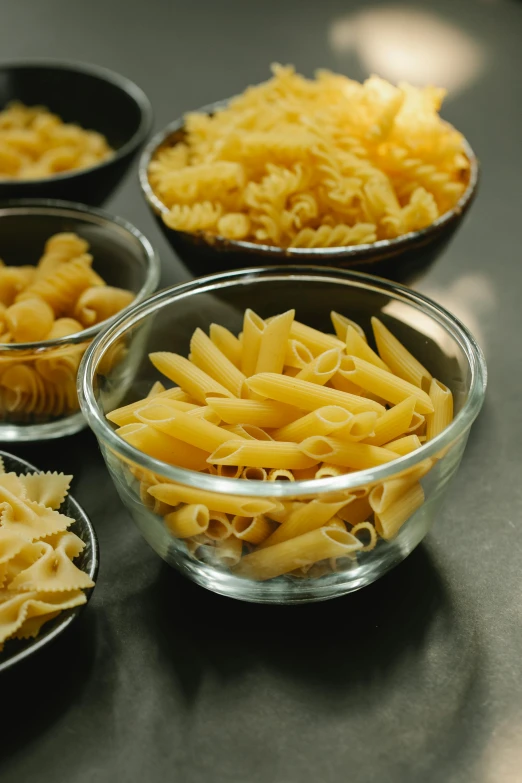 a table topped with bowls filled with different types of pasta, ultraclear intricate, medium close-up, 4l, petite