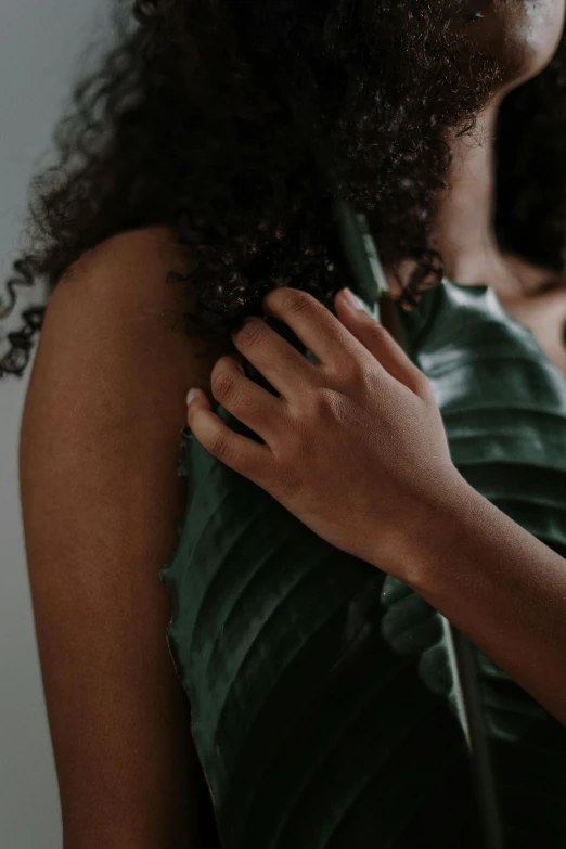 a woman with curly hair wearing a green dress, by Matija Jama, trending on pexels, palm skin, intimate holding close, wearing shoulder cape, leaves and simple cloth