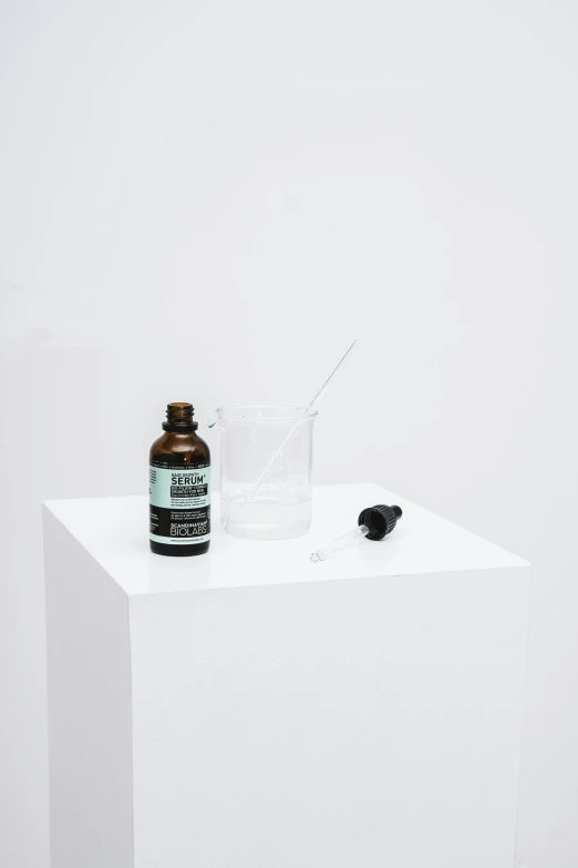 a bottle of liquid sitting on top of a white table, unsplash, visual art, clean white lab background, apothecary, black and green scheme, artforum aesthetic