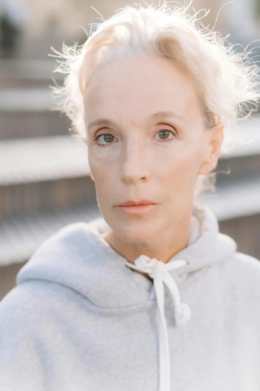 a close up of a person wearing a hoodie, inspired by Jean Cunningham, pale complexion, 5 5 yo, woman model, high view