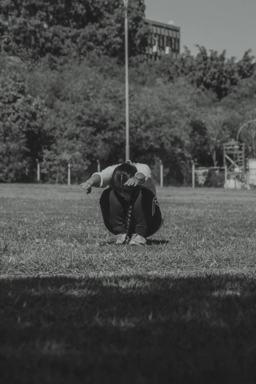 a black and white photo of a person doing a handstand, a black and white photo, unsplash, hurufiyya, on a football field, kneeling in prayer, islamic, old footage