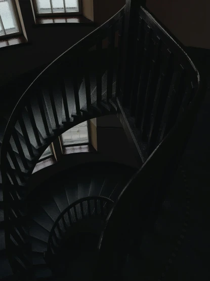 a black spiral staircase in a dark room, pexels contest winner, low quality photo, two stories, dark muted colors, a high angle shot