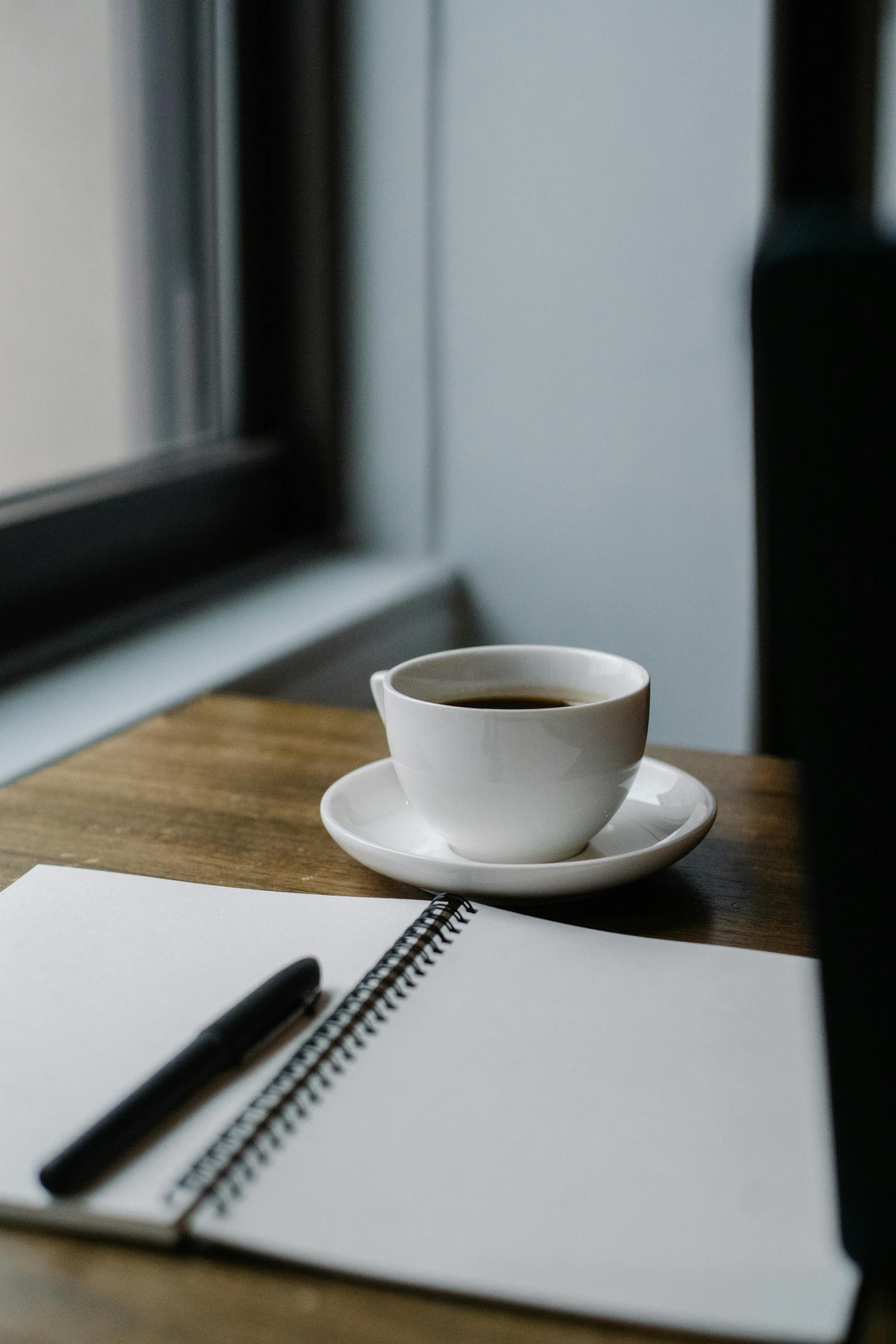 a cup of coffee sitting on top of a wooden table, by Daniel Seghers, unsplash, romanticism, pen on white paper, multiple stories, notebook, background image