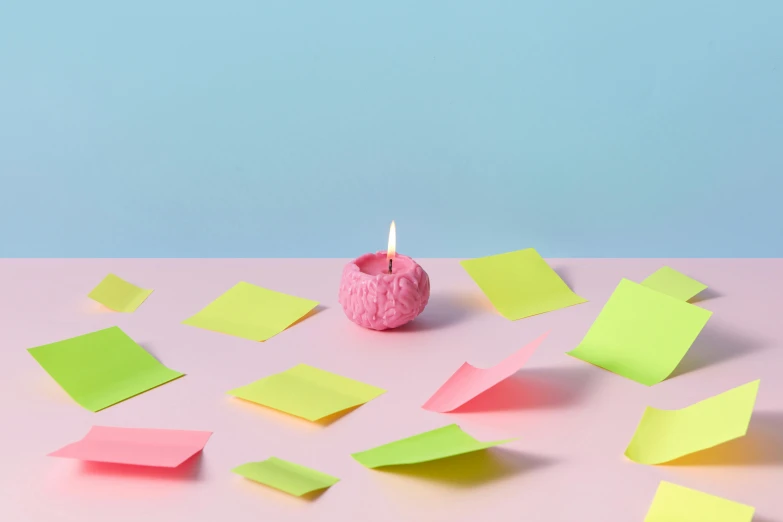 a donut sitting on top of a table covered in sticky notes, new objectivity, holding a candle, featuring pink brains, dezeen, bright colour