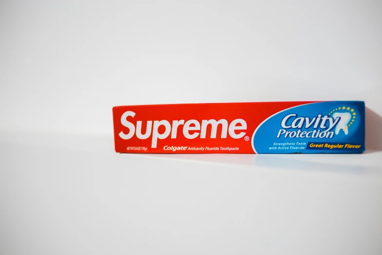 a tube of toothpaste on a white surface, supreme, cavern, - signature, protection