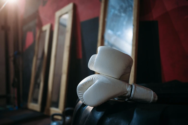 a pair of boxing gloves sitting on top of a black chair, a portrait, by Julia Pishtar, pexels contest winner, white belt, local gym, helmet view, thumbnail