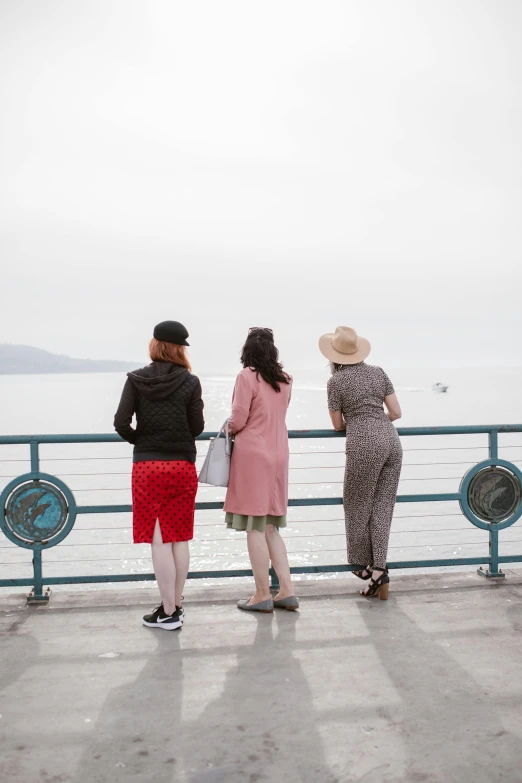 a group of people standing on top of a pier, three women, looking off into the distance, non-binary, seattle