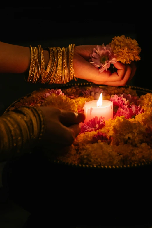 a close up of a person holding a lit candle, lamps and flowers, bangles, sharandula, light show