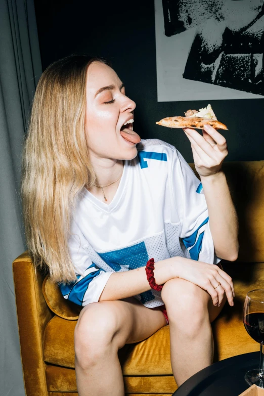 a woman sitting on a couch eating a slice of pizza, inspired by Elsa Bleda, pexels contest winner, renaissance, sophie turner girl, she is wearing streetwear, angelina stroganova, superbowl