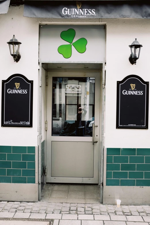 a building that has a bunch of signs on it, four leaf clover, inside a bar, doors, black an white