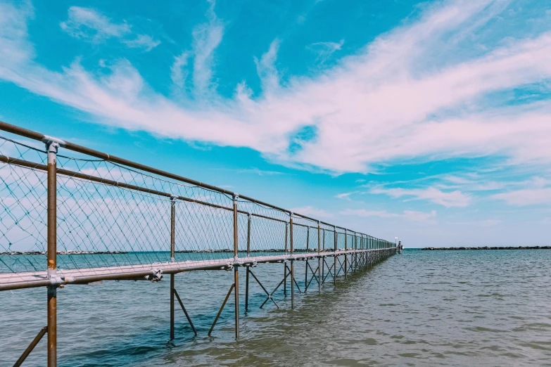 a wooden bridge over a body of water, unsplash contest winner, netting, blue skies, metallic bridge, seaview