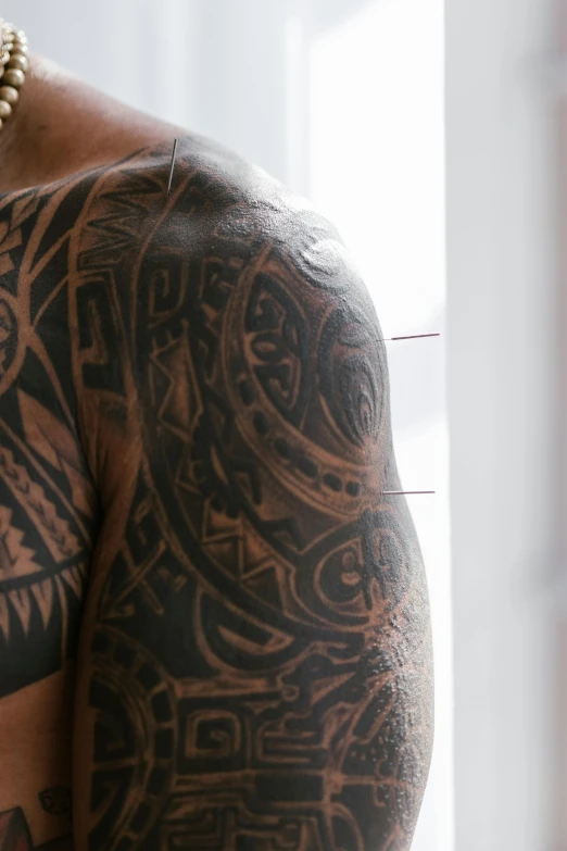 a man with a large tattoo on his chest, a tattoo, by Jessie Algie, trending on unsplash, samoan features, african american, down left arm and back, close up shot from the side