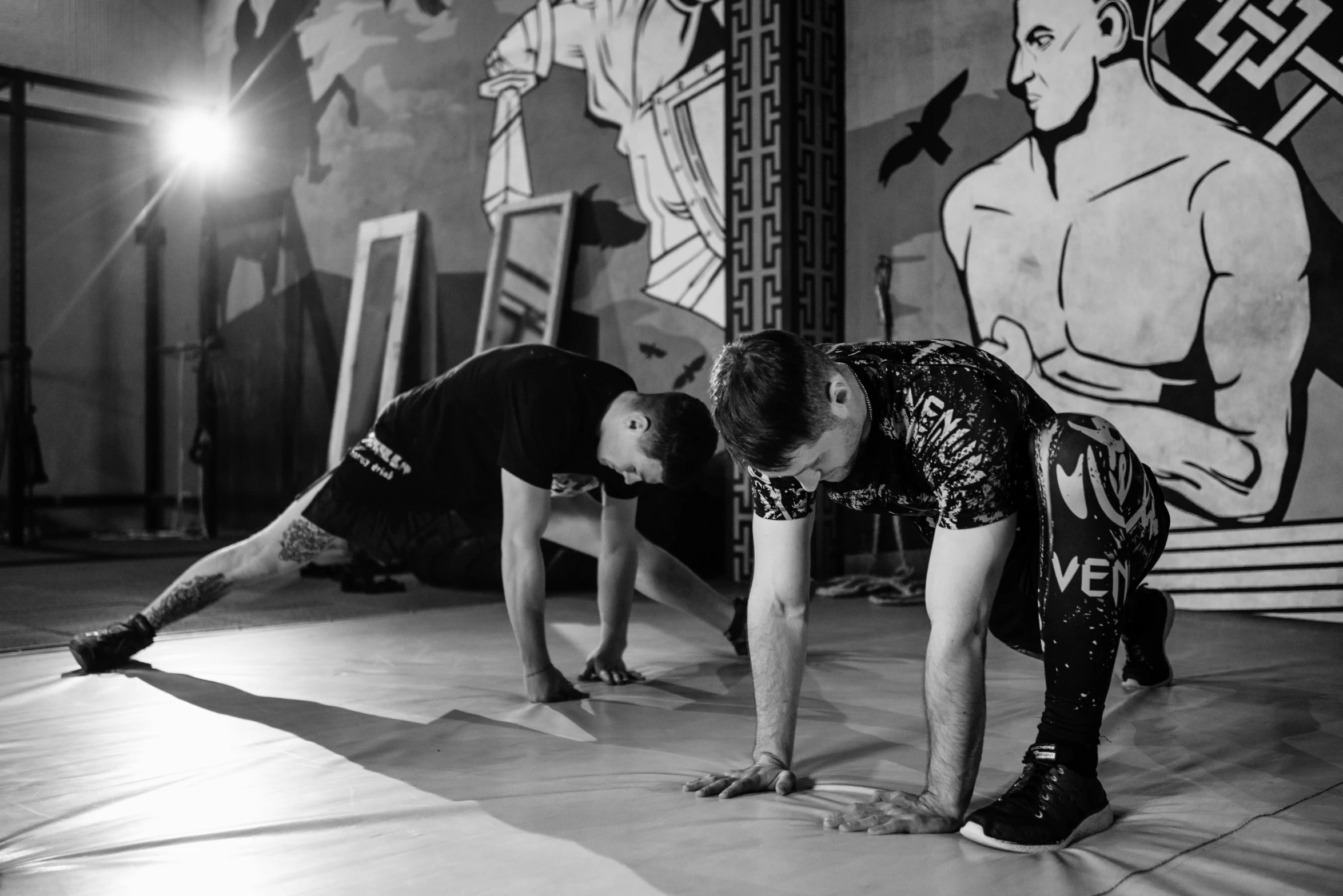 a black and white photo of two men doing push ups, visual art, hypervivid intense mcbess, grafit studio, official versace editorial, background