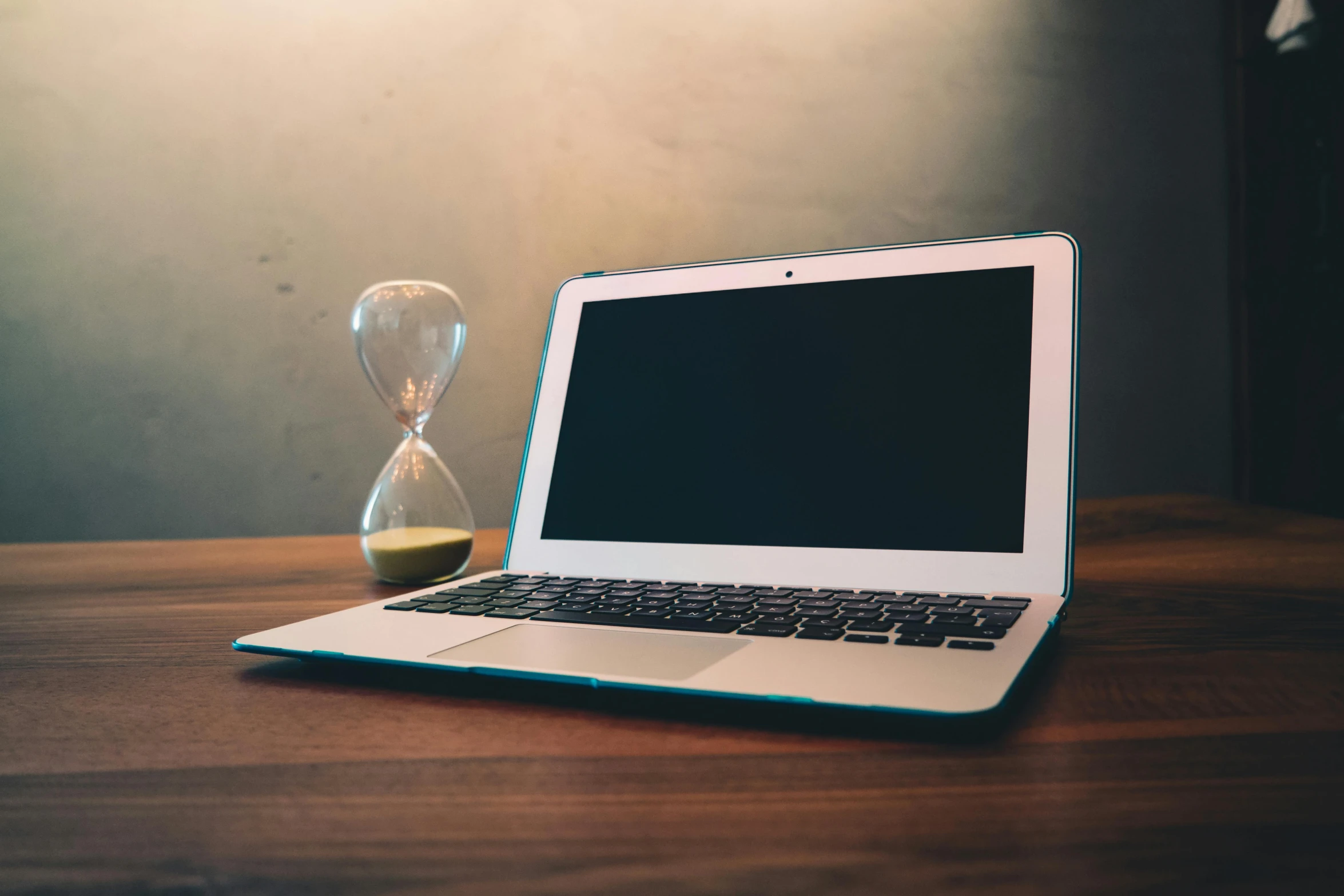 a laptop computer sitting on top of a wooden table, by Julia Pishtar, clock iconography, hour glass, blank, old school