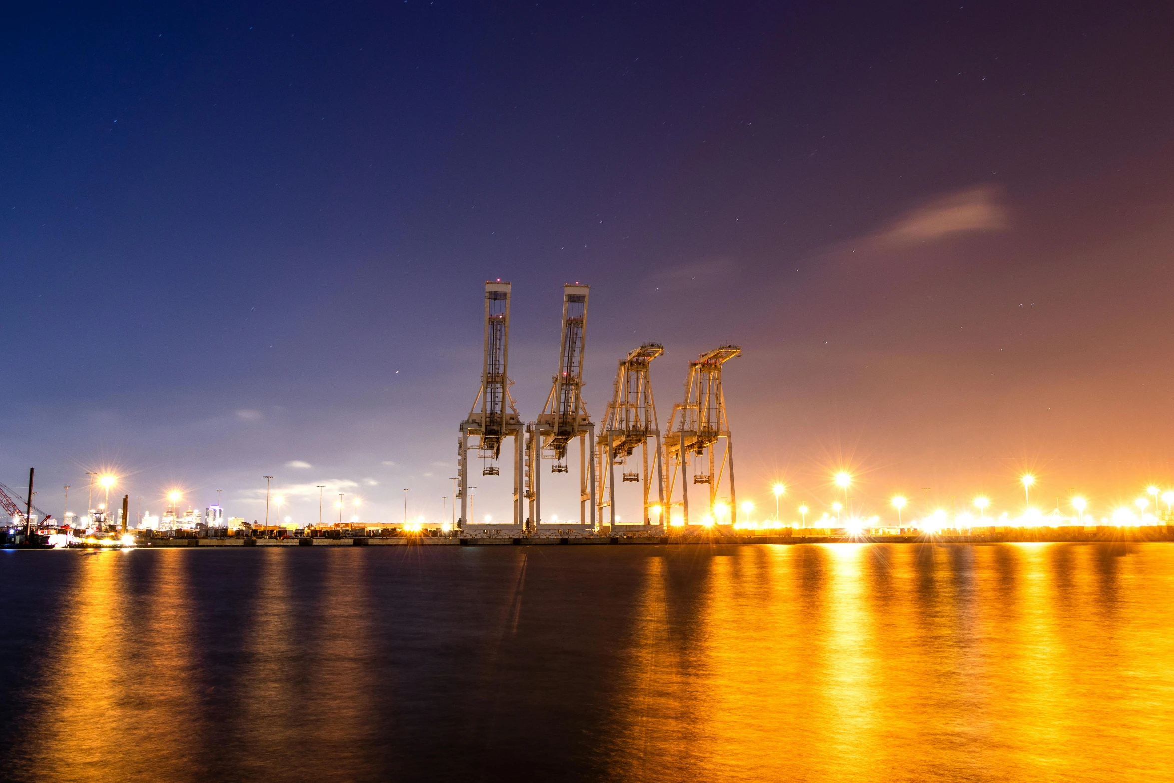 a large body of water with a bunch of cranes in the background, pexels contest winner, hurufiyya, terminals, set on night, instagram post, super high resolution