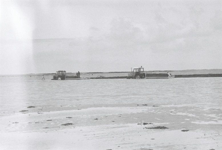 a black and white photo of two boats in the water, a black and white photo, by George Bell, land art, construction equipment 1 9 9 0, frozen sea, farming, album cover