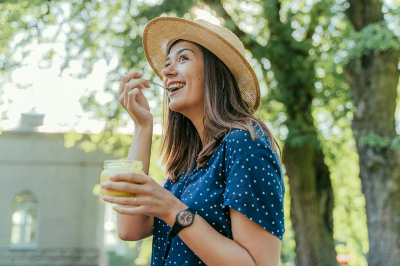 a woman with a straw hat drinking a drink, pexels contest winner, eating ice cream, manuka, smiling playfully, green