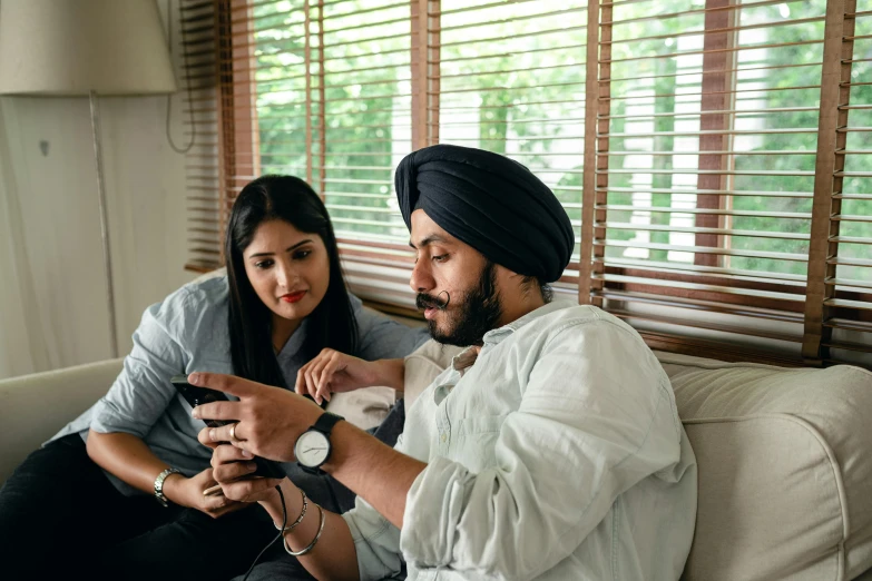 a man and a woman sitting on a couch, inspired by Manjit Bawa, trending on pexels, looking at his phone, avatar image, family photo, game