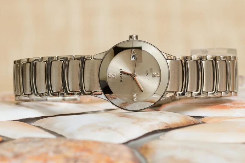 a close up of a wrist watch on a table, a portrait, flickr, gucci goddess, gradient brown to silver, tungsten, round-cropped